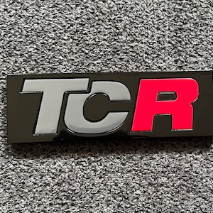 VW Golf Gti TCR emblem, logo for the radiator grille. Color: Pure Grey / Tornado Red