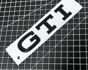 VW Golf 8 GTI tailgate emblem in piano black, genuine Volkswagen