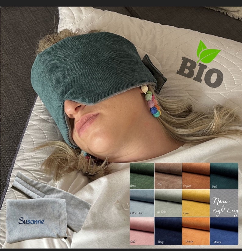 May include: A teal sleep mask covers the eyes of a person lying down. A matching pouch with the name "Susanne" embroidered on it is visible. The image also shows a color chart with fabric swatches and the word "BIO".