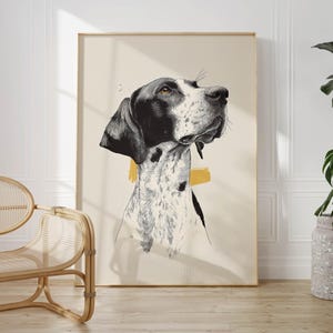 Op de afbeelding: Een ingelijste kunstdruk met een zwart-wit hondenportret. De hond heeft zwarte oren en een gespikkelde vacht. Een gele rechthoekige vorm bevindt zich achter de nek van de hond. Het kunstwerk wordt tentoongesteld in een kamer met een houten vloer en een rotan stoel.