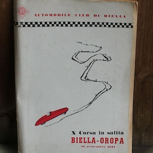 Peut inclure: Affiche vintage pour l'Automobile Club di Biella, avec une voiture de course rouge sur une piste sinueuse. L'affiche contient du texte en rouge et noir, avec le nom de l'événement "BIELLA-OROPA" et la date "21 septembre 1947".