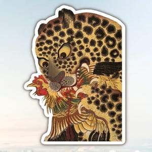 Peut inclure: Un autocollant découpé représentant une illustration détaillée d'un léopard au pelage beige tacheté de noir. Le léopard a la gueule ouverte et tient un poulet aux plumes rouges, jaunes et brunes. L'illustration est entourée d'une bordure blanche.
