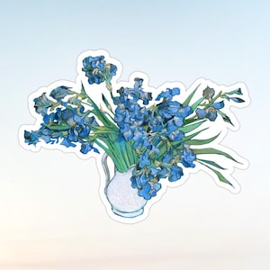 May include: A sticker featuring a reproduction of a painting of blue irises in a white pitcher. The flowers have deep blue petals with green stems and leaves, arranged in a bouquet. The white pitcher has a curved handle and a rounded base.