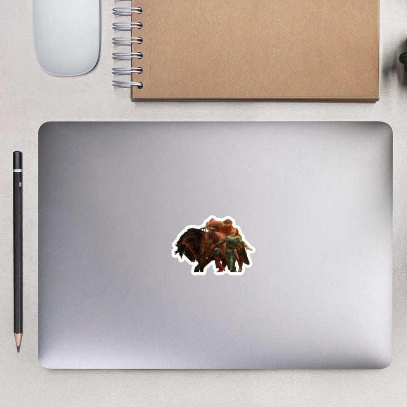 May include: A sticker featuring a fantasy scene with a large, dark brown creature, possibly a bull or bison, ridden by figures in red and green attire. The sticker is on a gray surface.