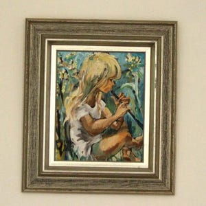 May include: A framed painting of a young person with long blonde hair playing a flute. The artwork uses a muted colour palette with blues, greens, and browns. The painting is set in a natural environment, with a light-coloured dress.