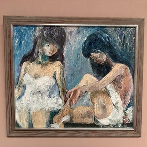May include: An oil painting in a wooden frame shows two figures. One stands in a white dress, the other sits, also in white. The background is blue, with visible brushstrokes. The artwork has a textured appearance.
