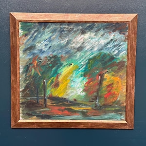 May include: An abstract painting in a wooden frame. The artwork features a landscape with a mix of colors, including green, yellow, red, and blue. The brushstrokes are visible, creating a textured effect. The painting is signed in the bottom right corner.