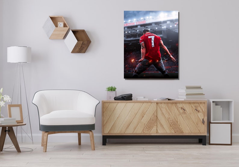 Op de afbeelding: Een rood-wit voetbaltenue met nummer 7 op de rug. Het tenue wordt gedragen door een speler die een doelpunt viert in een stadion. De tekst "Old Trafford" is zichtbaar op de achtergrond.