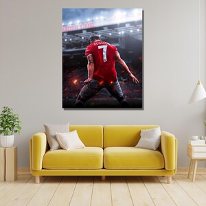 Op de afbeelding: Een voetballer in een rood shirt met nummer 7 en de naam "RONALDO" op de rug viert een doelpunt in een stadion. De speler staat met zijn rug naar de camera en heeft zijn armen in de lucht gestoken.