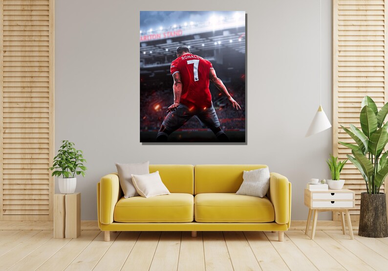 Op de afbeelding: Een voetballer in een rood shirt met nummer 7 en de naam "RONALDO" op de rug viert een doelpunt in een stadion. De speler staat met zijn rug naar de camera en heeft zijn armen in de lucht gestoken.