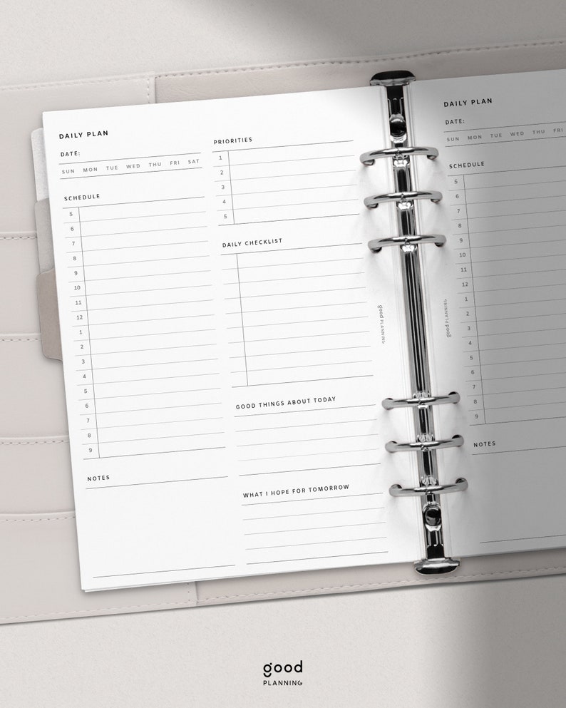 May include: A daily planner with a white background and black text. The planner has sections for daily tasks, priorities, a checklist, and notes. The planner is bound with silver rings.