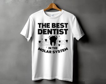 May include: White t-shirt with black text that reads "The Best Dentist in the Molar System". The text is surrounded by a black outline of a tooth and smaller teeth in a circle around it.