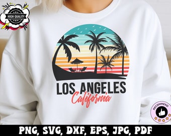 May include: A white sweatshirt with a graphic design of a sunset over palm trees and the text "LOS ANGELES California".