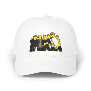 May include: White baseball cap featuring a graphic of five people with yellow and brown hair, wearing black, blue, and white shirts. The illustration has a cartoon style. The cap is made of a soft, durable material.