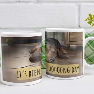 May include: White ceramic mug with a brown dachshund sleeping on a wooden floor. The mug has the text "It's been a LOOOONG day" printed on it.