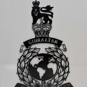 May include: Black and white metal wall art featuring a lion, crown, globe, and laurel wreath. The text "GIBRALTAR" and "PER MARE PER TERRAM" are included in the design.