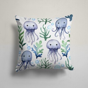 Funda de cojín decorativa con estampado de medusas de acuarela, caballitos de mar y conchas marinas.