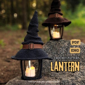 Könnte beinhalten: Zwei gehäkelte Laternen mit Hexenhut-Designs. Die Laternen sind dunkelblau und braun, mit lederartigen Riemen und Schnallen. Jede Laterne hat ein Glasgehäuse mit einer brennenden Kerze. Der Text "CROCHET PATTERN LANTERN" ist enthalten.