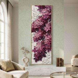 May include: A vertical rectangular oil painting featuring thick, textured impasto brushstrokes of deep magenta, violet, and soft pink flowers cascading against a white background, all enclosed within a thin, metallic gold frame.