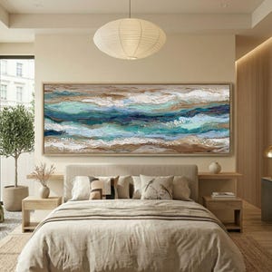 Peut inclure: Peinture abstraite d'une vague océanique dans des tons de bleu, turquoise, marron et blanc, au-dessus d'un lit. L'œuvre est encadrée dans un ton bois clair, créant un thème côtier serein pour la chambre.