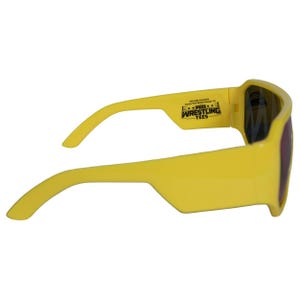 K&ouml;nnte beinhalten: Gelbe Sonnenbrille mit dunklen Gl&auml;sern. Die Sonnenbrille hat einen rechteckigen Rahmen und dicke, gebogene B&uuml;gel. Der Text "PRO WRESTLING TEES" ist auf dem B&uuml;gel aufgedruckt.