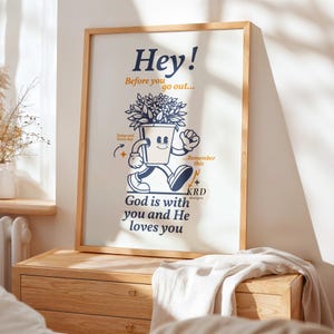 May include: A framed poster featuring a cartoon illustration of a potted plant walking. The text on the poster reads "Hey! Before you go out... Today and every day... Remember this... God is with you and He loves you."