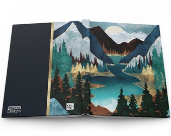 May include: Open book with a blue and green landscape illustration. The illustration features mountains, a lake, and trees. The book cover is dark blue with gold accents and the text "Spacefrog Designs".
