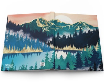 May include: An open book with a blue and green watercolor illustration of a mountain range with a lake reflecting the mountains. The mountains are accented with gold paint. The book has the text "Spacefrog Designs" on the front cover.