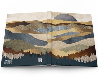 May include: A book with a blue and brown abstract landscape design on the cover. The design features a layered mountain range with a large, gray moon in the background. The book is open to reveal the same design on the inside pages.