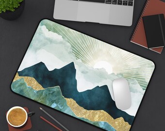May include: A blue and green mountain landscape with gold accents on a mouse pad. The design features a sun rising over the mountains with rays of light.