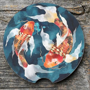 May include: Round car coaster featuring two koi fish in a yin-yang design. The fish are orange, red, and brown with white accents, set against a teal blue background with white cloud-like shapes.