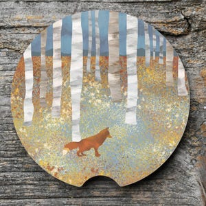 May include: Round car coaster featuring a forest scene with white birch trees, blue sky, and a brown fox. The coaster has a cutout for easy removal and is set against a wooden background.