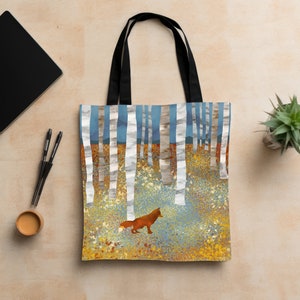 May include: A tote bag with a fox walking through a forest of birch trees. The trees are white with black markings and the forest floor is a mix of blue, yellow, and orange.