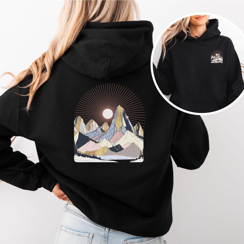Pu&ograve; includere: Felpa con cappuccio nera con un disegno di catena montuosa sul retro e una versione pi&ugrave; piccola sul davanti. La grafica della montagna include un sole e le montagne sono in tonalit&agrave; di blu, oro e rosa. La felpa ha un cappuccio e maniche lunghe.