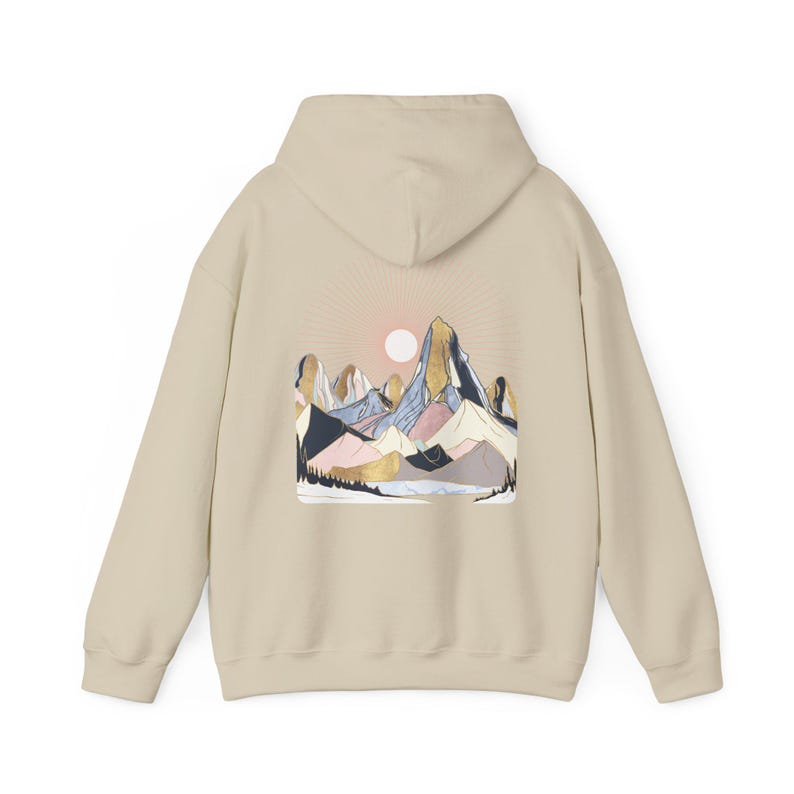 Pu&ograve; includere: Felpa con cappuccio beige con grafica di una catena montuosa sul retro. Il design include un sole, montagne nei toni del blu, rosa e oro e una silhouette di foresta. La felpa ha un cappuccio e maniche lunghe.