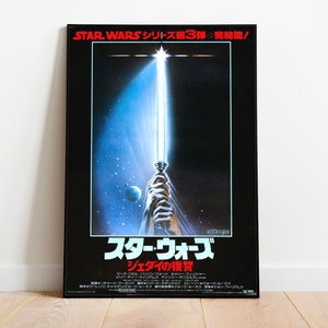 May include: A black and white poster for the movie Star Wars: Return of the Jedi. The poster features a lightsaber with a blue blade, a star field, and the Japanese text "STAR WARS シリーズ第3弾 完結篇/ スター・ウォーズ ジェダイの復讐".