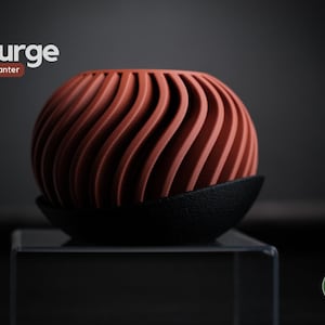 Könnte beinhalten: Ein terrakottafarbener, kugelförmiger Pflanztopf mit einem einzigartigen, wellenartigen Design. Der Pflanztopf steht auf einem schwarzen, strukturierten Sockel. Die Wörter "surge" und "planter" sind in Weiß und Braun dargestellt.