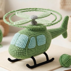 May include: A handmade green crochet helicopter toy with a light green rotor and blue window details. The helicopter has black landing skids and a gray accent on the rotor base. A ball of green yarn sits nearby.
