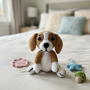 Könnte beinhalten: Ein gehäkelter Beagle-Hund mit braun-weißem Fell, großen schwarzen Augen und Schlappohren. Neben dem Hund befinden sich ein rosa Untersetzer, ein blauer Seestern und ein grüner Pilz, alle gehäkelt. Die Artikel befinden sich auf einer weißen Oberfläche.