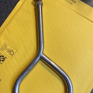 Pu&ograve; includere: Una maniglia in metallo argentato con un design arrotondato a forma di D. La maniglia &egrave; su una busta gialla con il testo "#2 Kraft Bubble Mailer 8.5 in x 11 in (21.6 cm x 27.9 cm)"