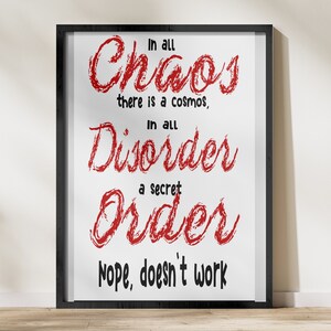 Könnte beinhalten: Schwarze gerahmte Wandkunst mit weißem Hintergrund und rotem Text, der lautet: "In all Chaos there is a cosmos, In all Disorder a secret Order. Nope, doesn't work."
