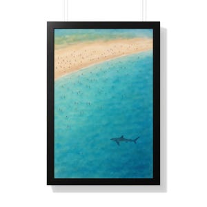 Könnte beinhalten: Gerahmter Kunstdruck, der eine Strandszene von oben zeigt. Das Kunstwerk zeigt einen Sandstrand, türkisfarbenes Wasser mit Schwimmern und einen Hai im Ozean. Der Druck befindet sich in einem schwarzen Rahmen.