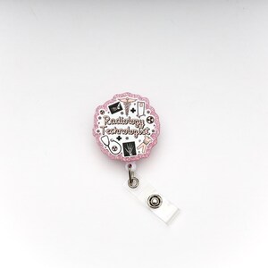 May include: A pink glitter badge reel with the words "Radiology Technologist" and medical-themed icons. The reel includes a white plastic clip and a retractable cord for attaching to clothing or a lanyard.