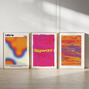 Könnte beinhalten: Drei gerahmte Poster mit abstrakten Designs in Orange-, Gelb-, Blau- und Rosatönen. Die Poster tragen den Text "Ultra 2023", "Blossom" und "Exotic 2023".