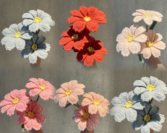 Puede incluir: Un conjunto de tres ramos de flores de ganchillo en rosa, rojo y azul claro. Cada ramo tiene cinco flores con centros amarillos.