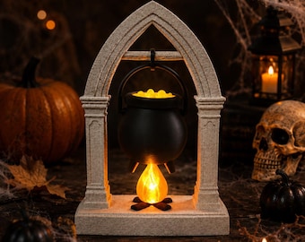 Puede incluir: Un caldero negro cuelga de un marco de arco gótico de color piedra. El caldero está lleno de un contenido amarillo brillante y una luz naranja en forma de llama se encuentra debajo en la base, creando un efecto cálido e iluminado.
