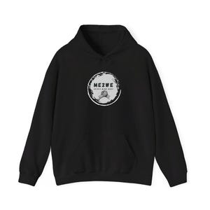 Puede incluir: Sudadera con capucha negra con un logotipo circular blanco que dice "ME2WE SPIRIT MIND BODY" con un gráfico de apretón de manos dentro del círculo.