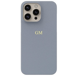 May include: A light blue leather phone case with a gold monogram "GM" on the back.