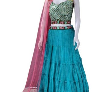 May include: A turquoise layered skirt with a green and gold embroidered bodice and a pink sheer dupatta. The outfit is perfect for a special occasion.
