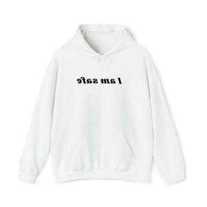 Puede incluir: Sudadera con capucha blanca con un gráfico negro que dice "I am safe" en una fuente retro.